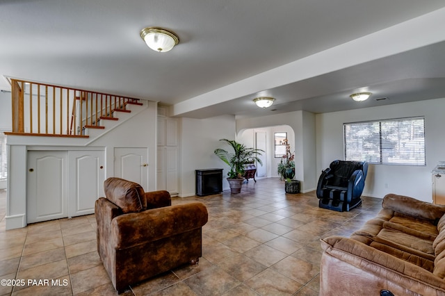 living area with stairs, visible vents, and light tile patterned flooring