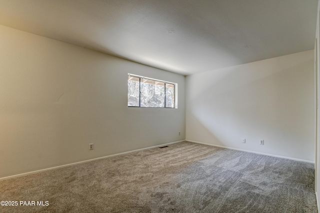 empty room featuring carpet, visible vents, and baseboards