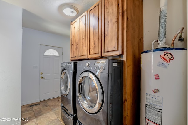 laundry area with gas water heater, cabinet space, and washer and dryer