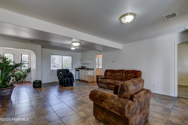 living area featuring visible vents, dark tile patterned floors, and baseboards