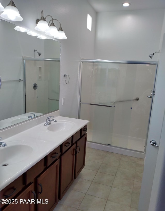 bathroom featuring a stall shower, tile patterned flooring, and a sink