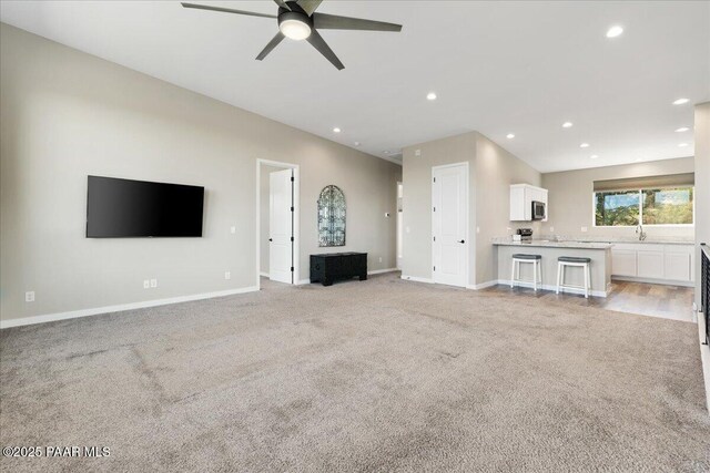 1841 N Jade Cir, Prescott, AZ 86301 - unfurnished living room with light carpet, a ceiling fan, baseboards, recessed lighting, and a sink