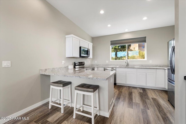 1841 N Jade Cir, Prescott, AZ 86301 - kitchen with appliances with stainless steel finishes, dark wood-type flooring, a peninsula, white cabinetry, and light stone countertops