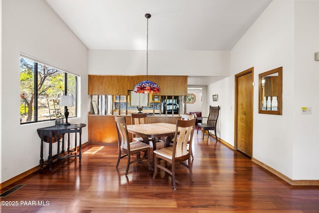 dining space with baseboards, a notable chandelier, visible vents, and a towering ceiling