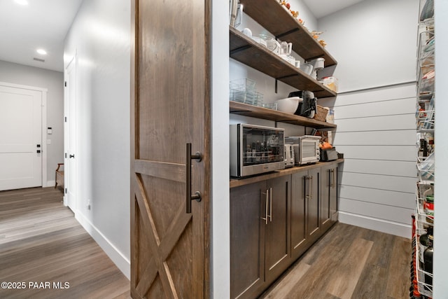 bar with baseboards, wood finished floors, and recessed lighting