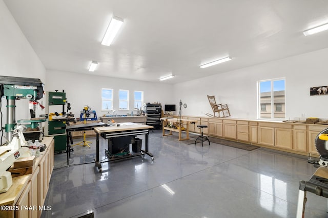 miscellaneous room featuring finished concrete floors and a workshop area