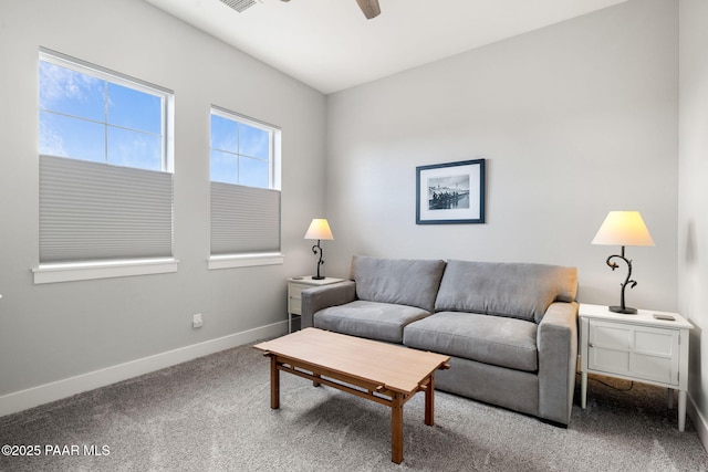 carpeted living area with a ceiling fan and baseboards