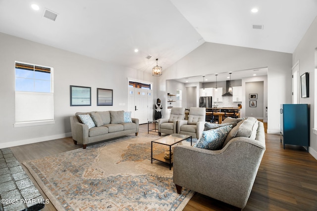 living area with visible vents, high vaulted ceiling, and dark wood-type flooring