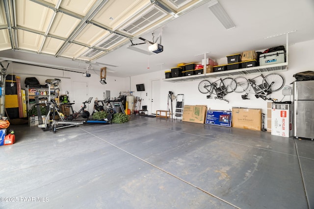 garage with a garage door opener and freestanding refrigerator