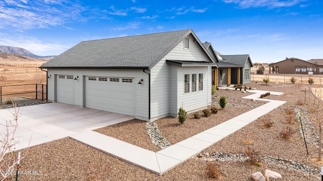 view of front facade featuring roof with shingles, fence, and a mountain view