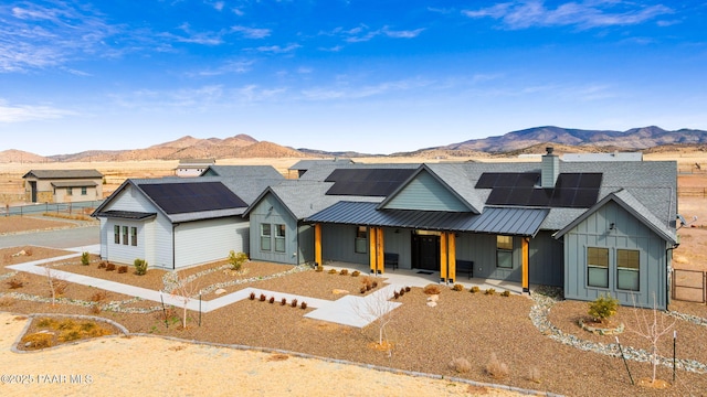 modern inspired farmhouse featuring covered porch, a standing seam roof, board and batten siding, and a mountain view