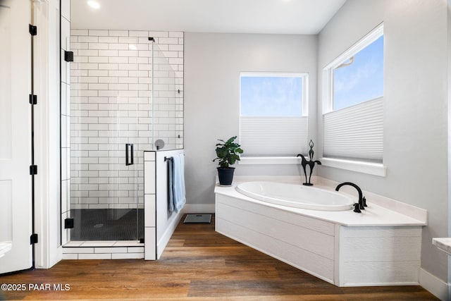 bathroom with a garden tub, recessed lighting, wood finished floors, and a stall shower