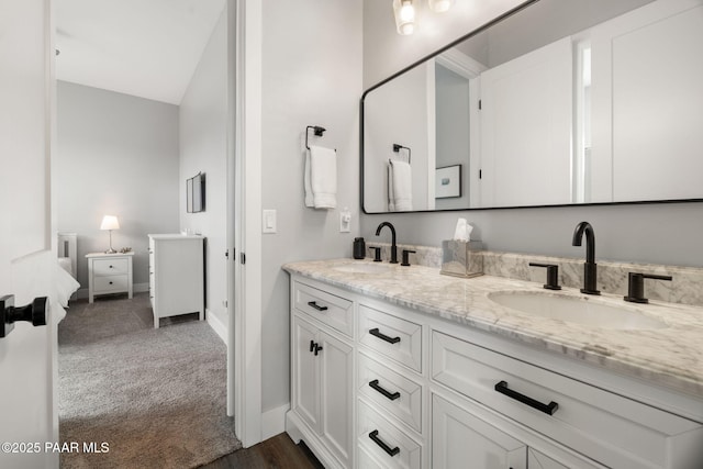 bathroom featuring double vanity, a sink, and baseboards