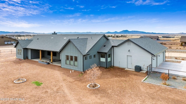 rear view of property featuring a garage, driveway, board and batten siding, and a mountain view