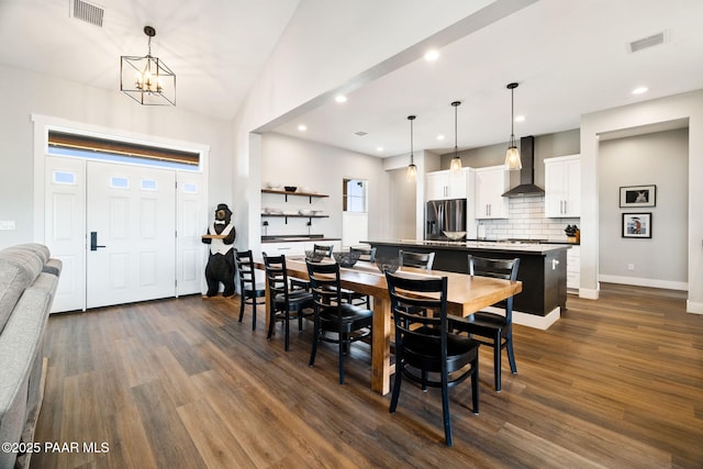 dining area with dark wood-type flooring, visible vents, and baseboards