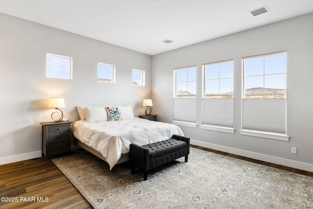 bedroom featuring visible vents, baseboards, and wood finished floors