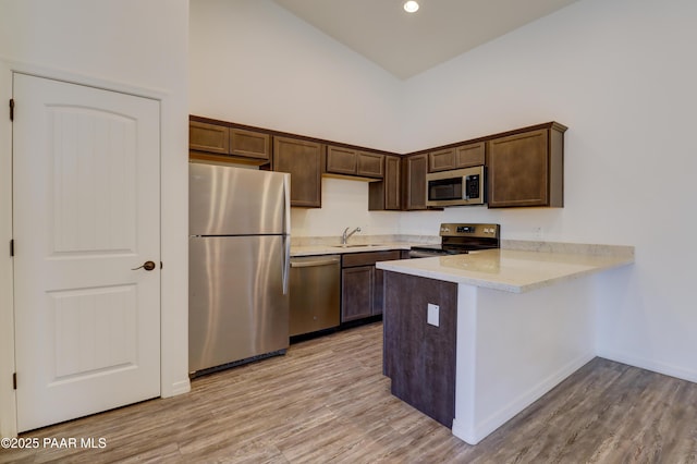 8346 Florentine Rd, Prescott Valley, AZ 86314 - kitchen with appliances with stainless steel finishes, light countertops, dark brown cabinetry, light wood finished floors, and recessed lighting
