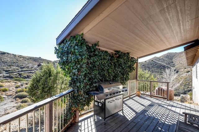 wooden deck with a grill and a mountain view