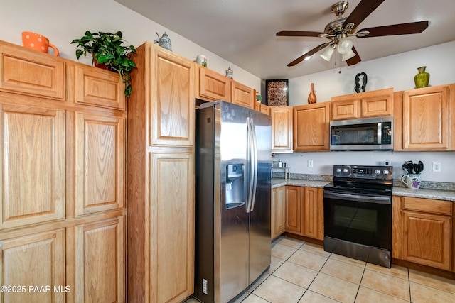 kitchen featuring ceiling fan, stainless steel appliances, and light tile patterned flooring