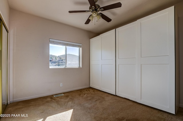 unfurnished bedroom with visible vents, baseboards, ceiling fan, carpet, and a closet