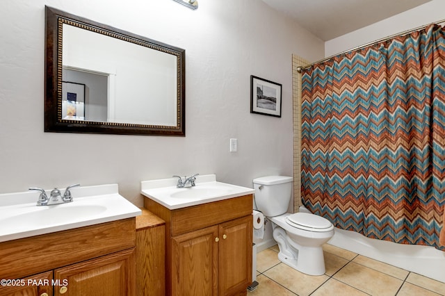 bathroom with toilet, two vanities, a sink, and tile patterned floors