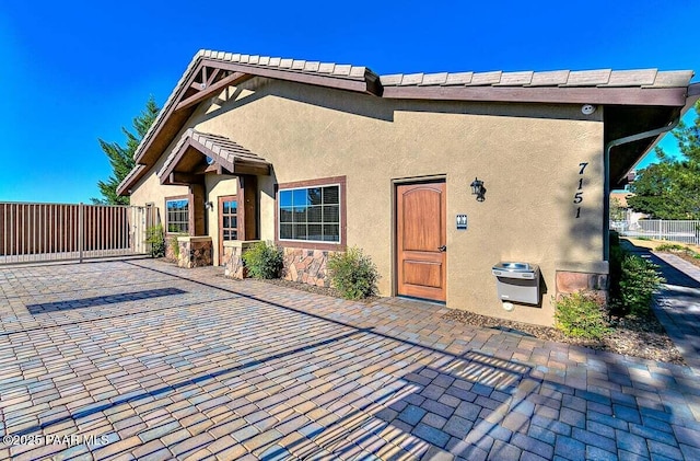 7461 N Windy Walk Way, Prescott Valley, AZ 86315 - view of front facade with stucco siding, a gate, and a patio area