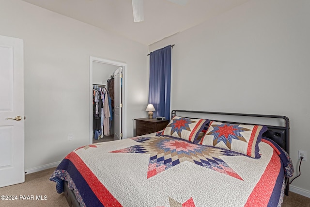 carpeted bedroom with ceiling fan, a spacious closet, and a closet