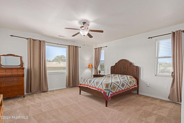 carpeted bedroom with multiple windows and ceiling fan