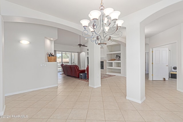 tiled dining space with ceiling fan with notable chandelier and built in features