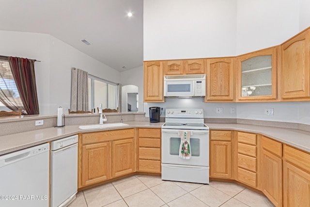 kitchen featuring sink, light tile patterned floors, white appliances, and light brown cabinets