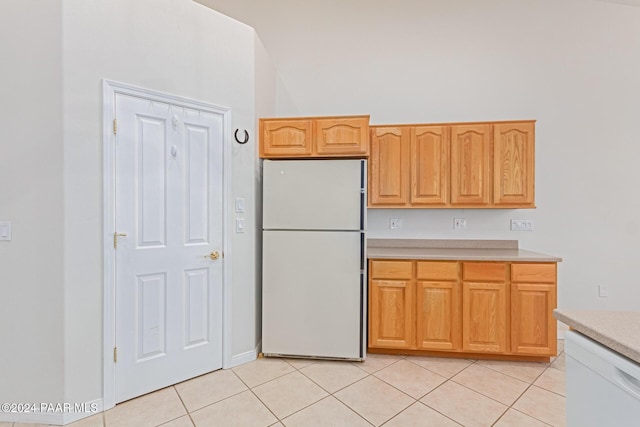 kitchen featuring light tile patterned flooring and white appliances