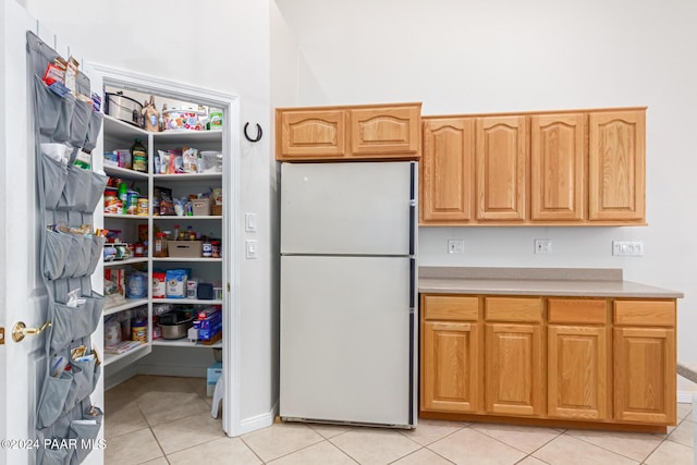 kitchen with white fridge and light tile patterned floors