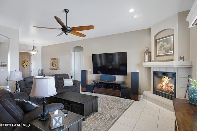 living room featuring light tile patterned floors, ceiling fan, and a tiled fireplace