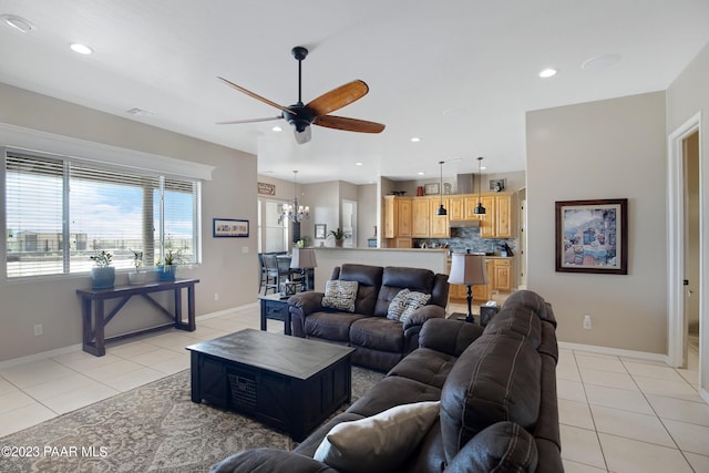 tiled living room featuring ceiling fan with notable chandelier