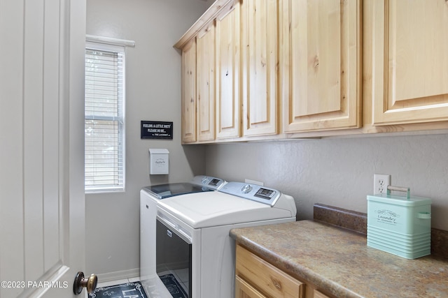 clothes washing area featuring cabinets and washing machine and clothes dryer