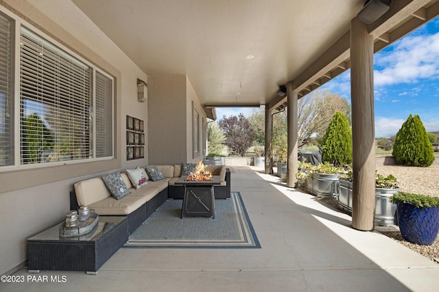 view of patio with an outdoor living space with a fire pit