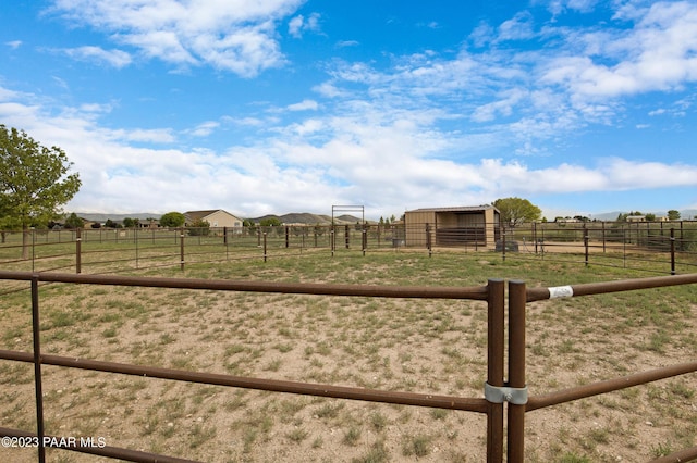 view of yard featuring a rural view and an outdoor structure