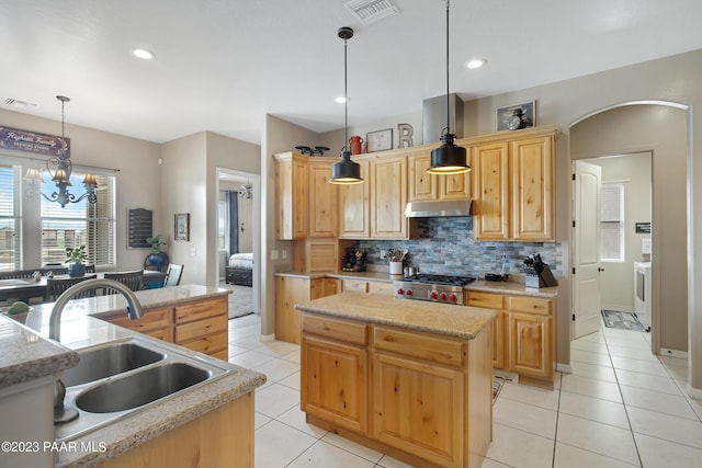 kitchen featuring a center island, sink, hanging light fixtures, an inviting chandelier, and light brown cabinetry