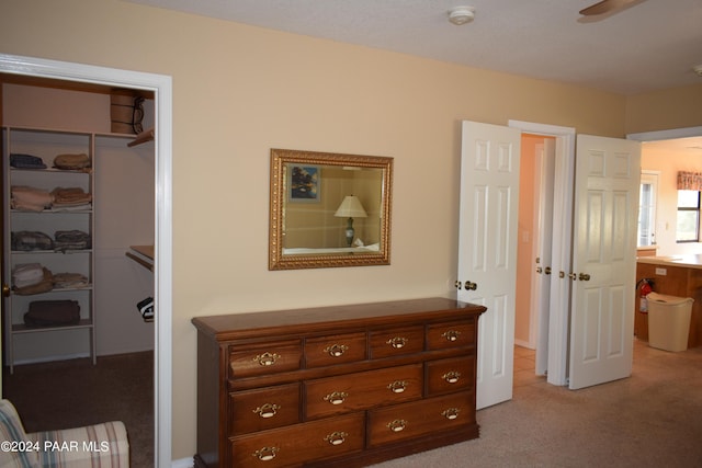 carpeted bedroom with ceiling fan and a closet