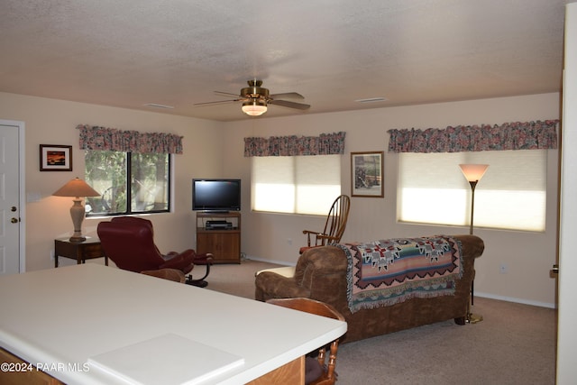 carpeted bedroom with ceiling fan and a textured ceiling