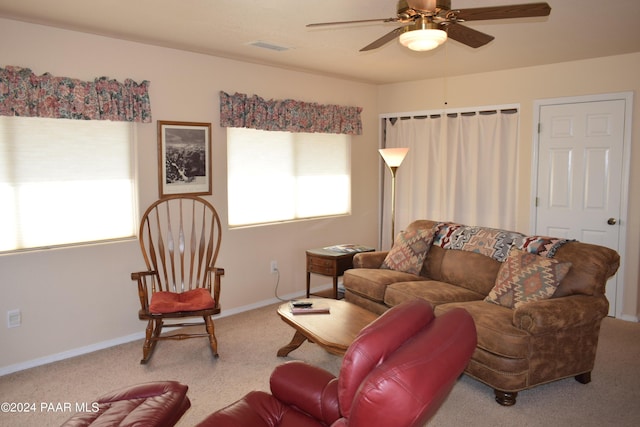 living room featuring carpet floors, ceiling fan, and a healthy amount of sunlight