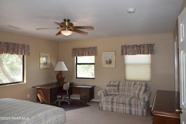 carpeted bedroom with ceiling fan and a textured ceiling