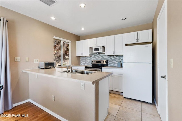 3050 Smokey Rd Unit 20D, Prescott, AZ 86301 - kitchen with white appliances, white cabinets, decorative backsplash, light countertops, and a peninsula