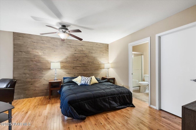 3050 Smokey Rd Unit 20D, Prescott, AZ 86301 - bedroom with wood finished floors, wood walls, an accent wall, ensuite bathroom, and a ceiling fan