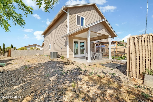 rear view of house with french doors, cooling unit, and a patio