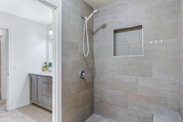 bathroom featuring tile patterned floors, vanity, and a tile shower