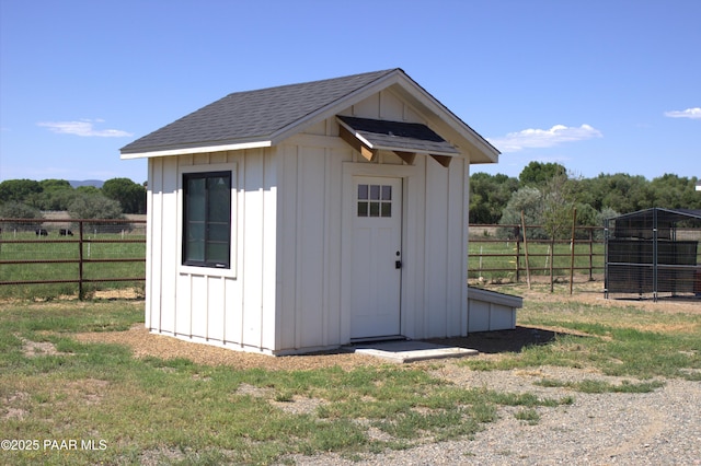 view of shed featuring a rural view and fence