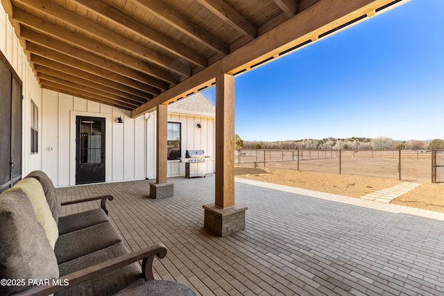 view of patio with a grill and fence