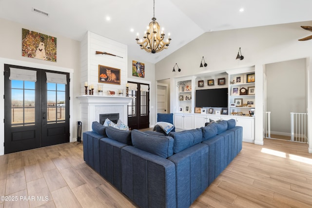 living area with french doors, high vaulted ceiling, a chandelier, and light wood finished floors