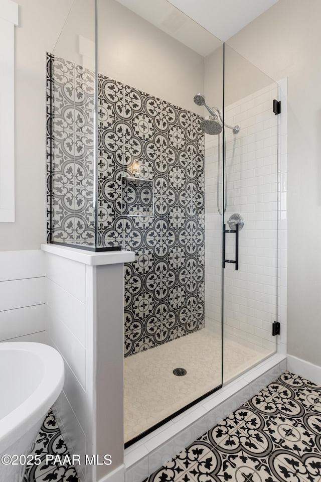 full bathroom with tile patterned floors, a soaking tub, and a stall shower